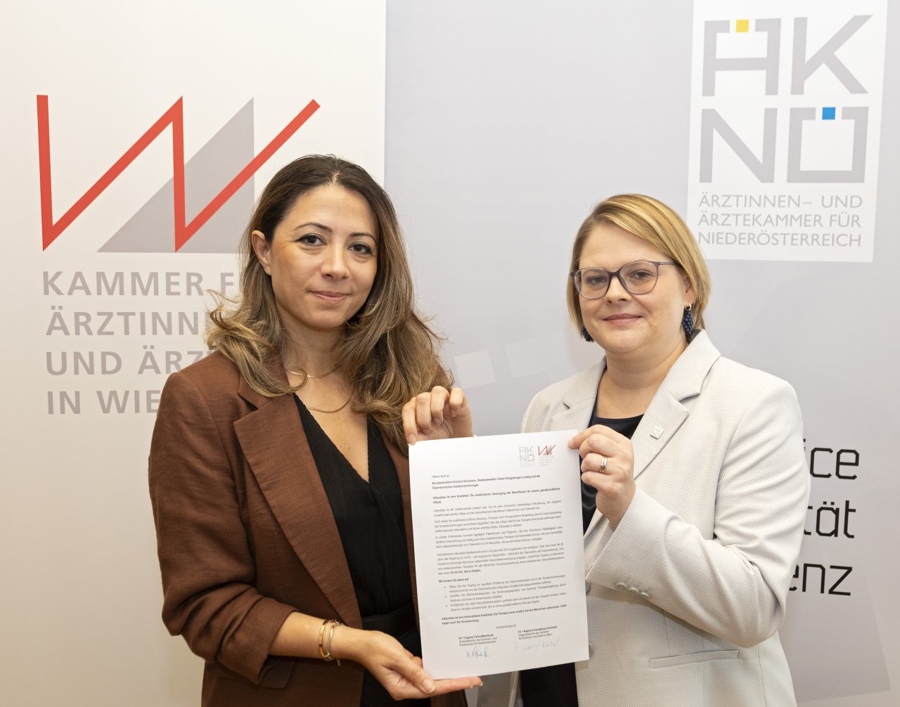 Zwei Frauen halten ein Schreiben in der Hand.