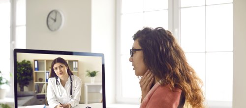Eine Frau erklärt einer Ärztin via Telemedizin über einen Bildschirm ihre Beschwerden.
