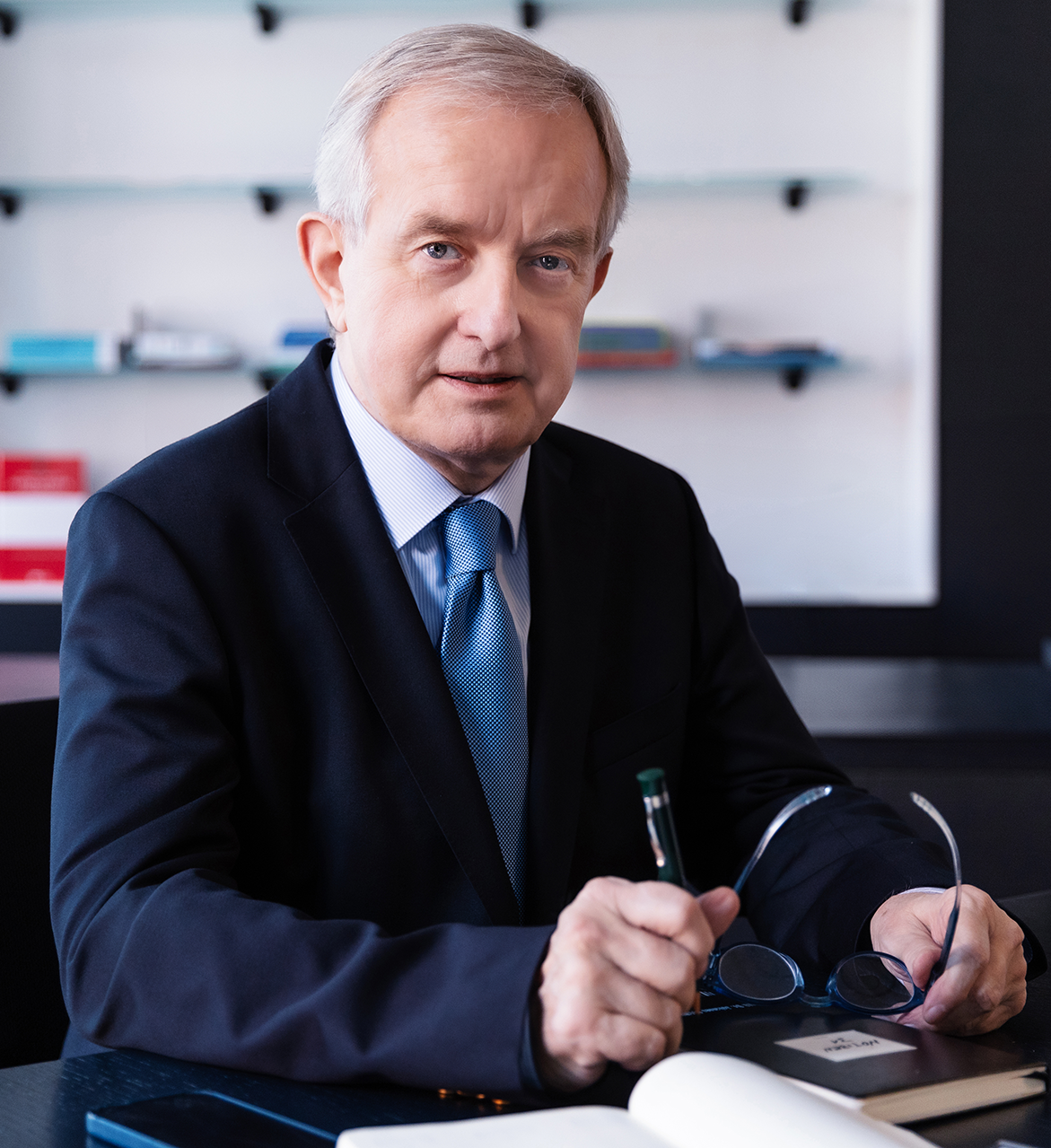 Mann mit Krawatte und Brille, am Schreibtisch sitzend