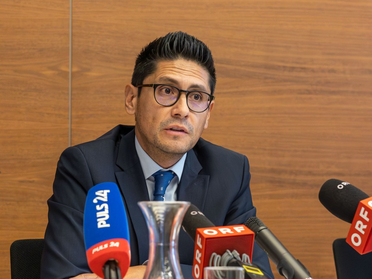 Ein spricht im Rahmen einer Pressekonferenz und blickt entschlossen nach vorne.