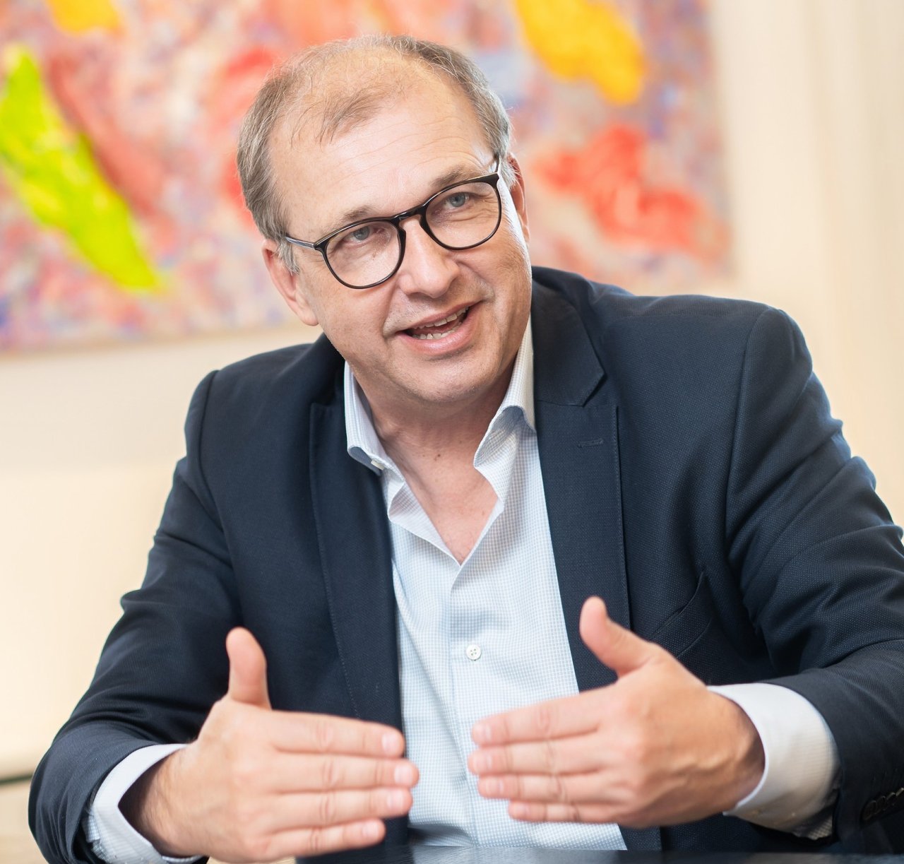 Thomas Holzgruber beim Gespräch an einem Tisch sitzend.