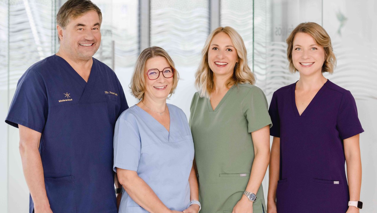 Eine Gruppe von vier Personen steht nebeneinander - eine Person ist männlich.