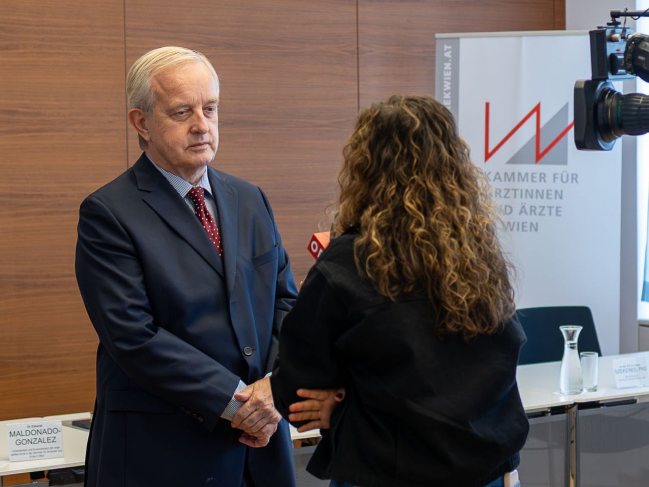 Ein Mann wird von einer Frau interviewt.
