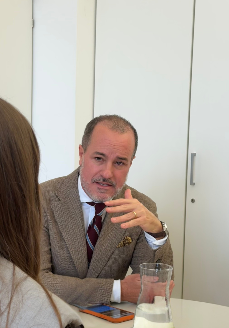 Mann in grauem Anzug gestikuliert in Gesprächssituation