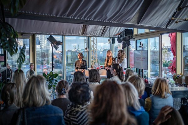 Blick in einen mit zahlreichen Menschen gefüllten Veranstaltungssaal.