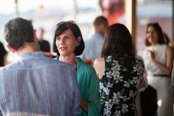 Größere Personengruppe beim Medienfest, mit Bildfokus auf eine Medienvertreterin. 