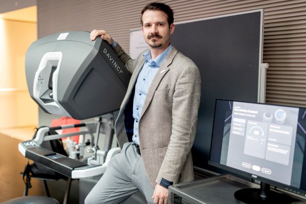 Mann mit dunklen Haaren lehnt bei einem Bildschirmgerät