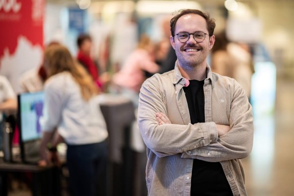 Mann mit hellbraunem Hemd und Brille.