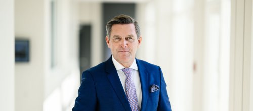 Porträtbild von Mann in Anzug. 