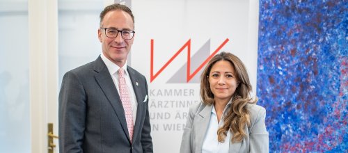 Ein Mann und eine Frau (rechts) stehen nebeneinander im Rahmen einer Pressekonferenz nebeneinander.