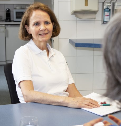 Frau Susanne Equiluz-Bruck sitzt an einem Tisch im Rahmen eines Interviews