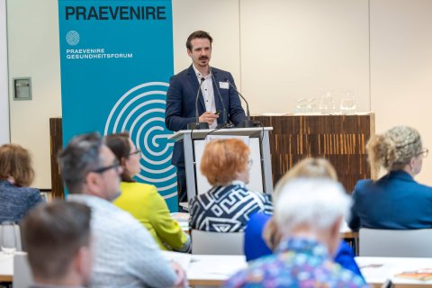 Mann am Podium mit Publikum