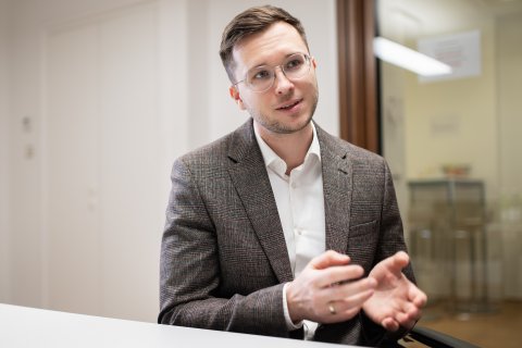 Junger Mann im Anzug gestikuliert