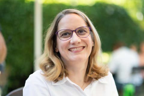 Frau mit Brille lächelt in die Kamera.