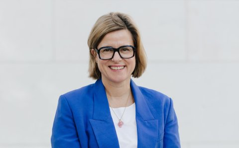 Frau in Jacke und Brille schaut frontal in die Kamera