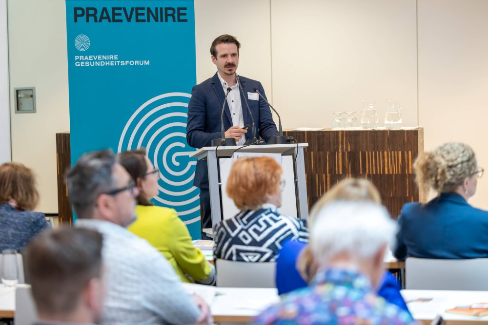 Mann am Podium mit Publikum