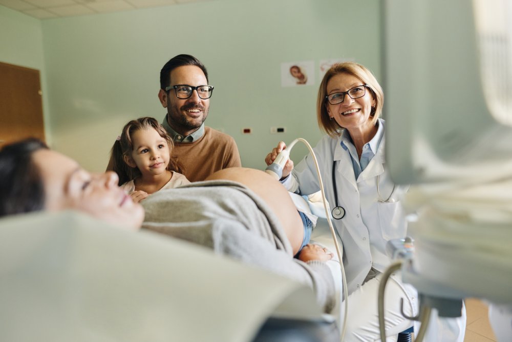 Eine Familie ist bei der Untersuchung im Rahmen des Eltern-Kind-Passes.