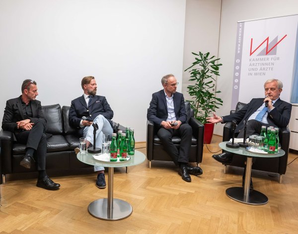 Beim KI-Symposium sitzen, von links nach rechts, die Herren Andreas Klein, Bart de Witte, Christoph Bock und Johannes Steinhart beisammen und diskutieren.