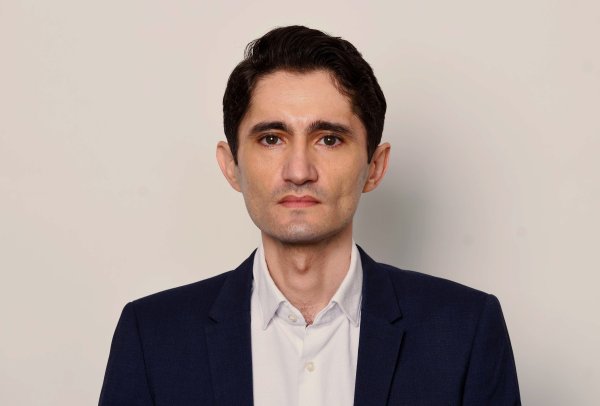 Der Journalist Köksal Baltaci von "Die Presse" blickt direkt in die Kamera. Der Hintergrund ist hell und einfärbig. 