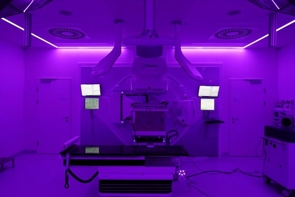 Ein Foto von einer Radioonkologie-Strahlenanlage - der Raum ist in violettes Licht getaucht.