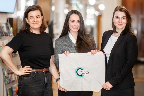 Drei Frauen halten ein Schild mit chiruginnen.connect