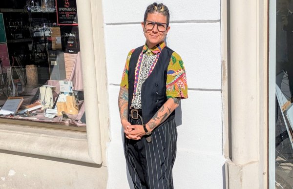 Frau steht an der Mauer gelehnt