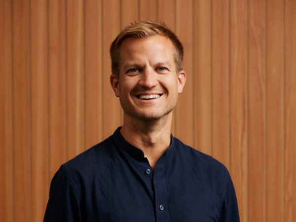 Ein Mann blickt in die Kamera und lächelt.