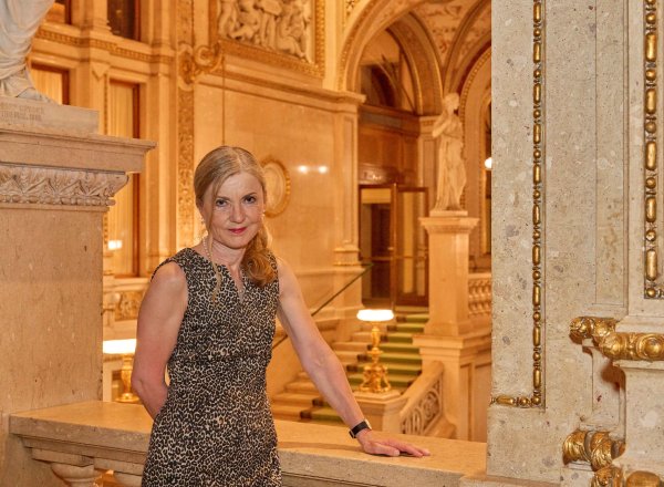 Eine Frau steht im Stiegenhaus der Wiener Staatsoper.